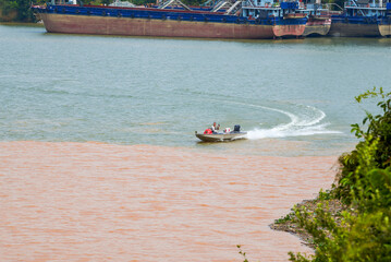 Obraz premium A sailor drives a speedboat at the confluence of two rivers
