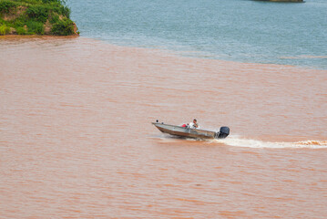 A sailor drives a speedboat at the confluence of two rivers