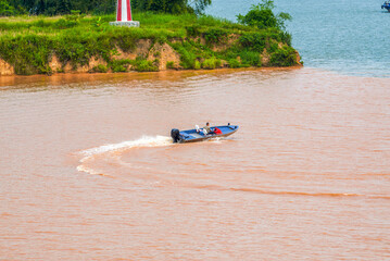 Fototapeta na wymiar A sailor drives a speedboat at the confluence of two rivers
