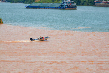 A sailor drives a speedboat at the confluence of two rivers