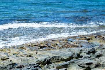 Fototapeta na wymiar Waves Breaking on a Rock Beach in Hawaii.