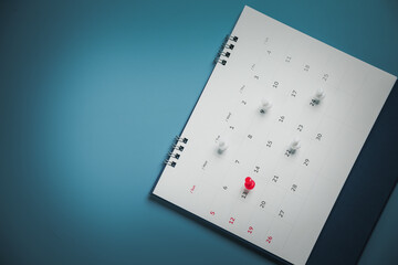 Embroidered red pins on a calendar event Planner calendar,clock to set timetable organize schedule,planning for business meeting or travel planning concept.