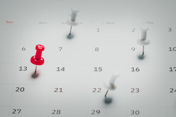 Embroidered red pins on a calendar event Planner calendar,clock to set timetable organize schedule,planning for business meeting or travel planning concept.