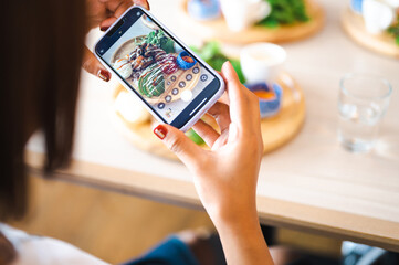 スマホで料理を撮影する女性