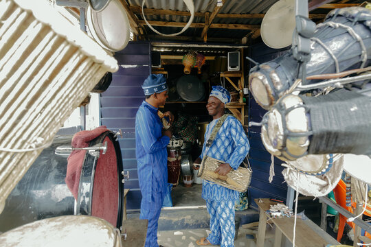 Elderly father and son playing talking drums