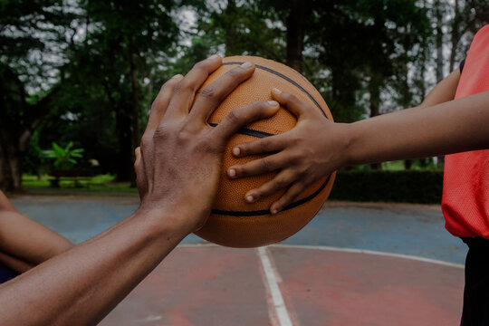 Hands of Father and son on ball