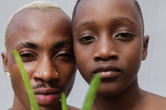 Headshots of blonde father and son with an aloe vera plant