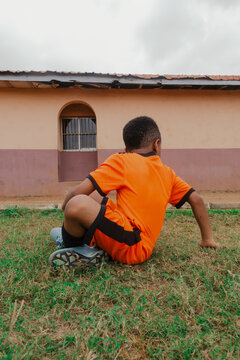 Boy looking back while sitting on grass