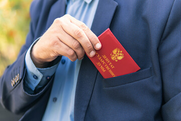 Man in blue suit shows red ID card or pass. An important untouchable employee of ministry is...