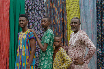 African father and children in traditional attire looking with hands over one another - obrazy, fototapety, plakaty