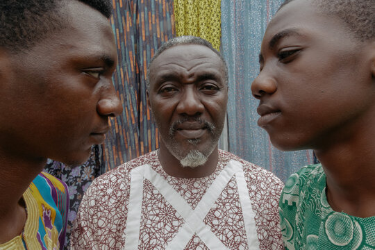 African dad in late 50s standing between two sons 
