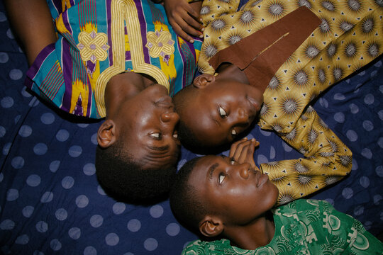 Nigerian brothers laying and looking at each other