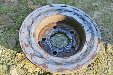 Non vented old broken crooked car brake rotor disc with spotty wear from vibration after manual...