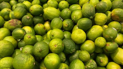 Pile of fresh green sour lemons close up