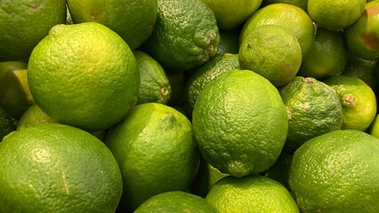 Pile of fresh green sour lemons close up