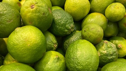 Pile of fresh green sour lemons close up