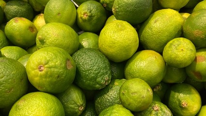 Pile of fresh green sour lemons close up