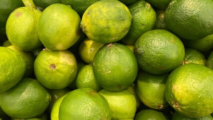 Pile of fresh green sour lemons close up