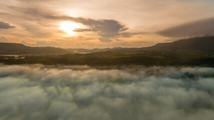 Mountains in fog at beautiful autumn in Phetchabun Thailand. Fog mountain valley, low clouds, forest, colorful sky with.  pine trees in spruce foggy forest with bright sunrise