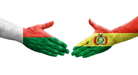 Handshake between Bolivia and Madagascar flags painted on hands, isolated transparent image.