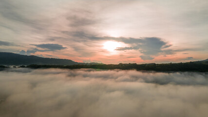 Mountains in fog at beautiful autumn in Phetchabun Thailand. Fog mountain valley, low clouds, forest, colorful sky with.  pine trees in spruce foggy forest with bright sunrise