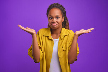 Young attractive uncomprehending African American woman throws up hands as sign of lack of ideas...