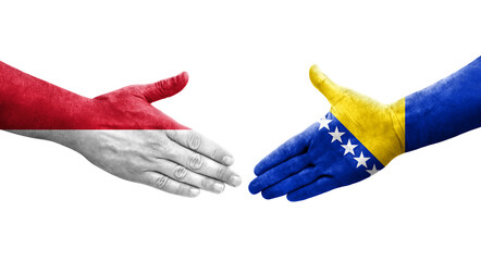 Handshake between Bosnia and Monaco flags painted on hands, isolated transparent image.