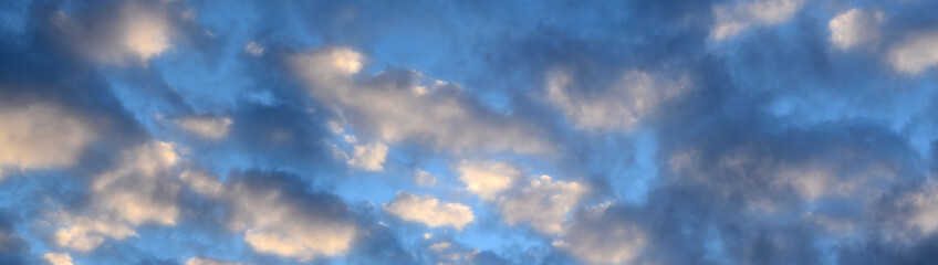 Dark and glowing red clouds clouds in the blue sky at sunrise.Dark red cloudy landscape. The beauty of nature, panorama