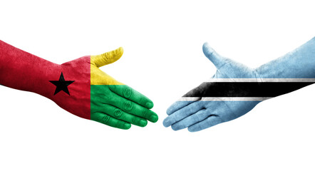 Handshake between Botswana and Guinea Bissau flags painted on hands, isolated transparent image.
