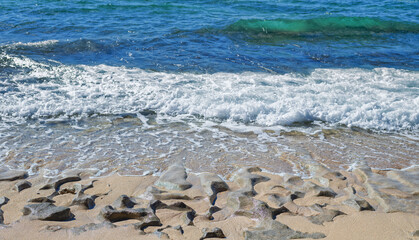 Sand and Lave Shoreline with Breaking Waves on Diamond Head Beach, Hawaii.