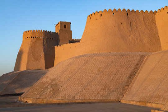 Walls and bastion of the ancient fortress Kuhna Ark in the light of the evening sun. Khiva, Uzbekistan