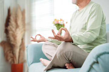 Asian elderly senior old man doing yoga relax in living room at home, Mature retirement happy...