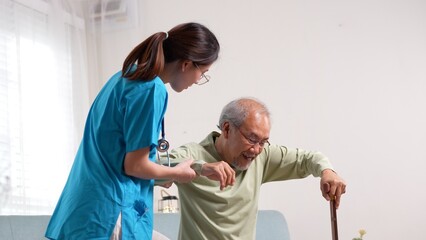 Asian senior elderly man patient doing physical therapy with caregiver. woman nurse helping get up...