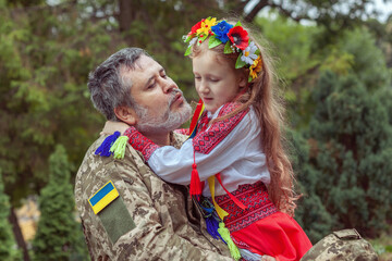 Portrait of a Ukrainian soldier with his little daughter.
