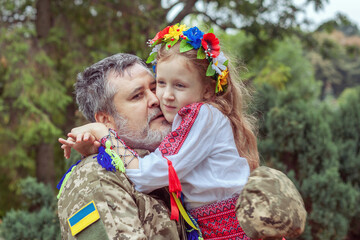Portrait of a Ukrainian soldier with his little daughter.