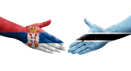 Handshake between Botswana and Serbia flags painted on hands, isolated transparent image.