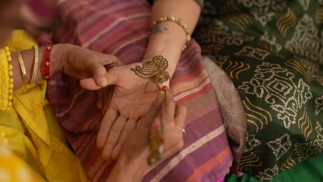 Woman hand being decorated with henna, mehndi 