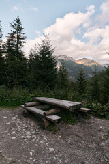 Empty outdoor wooden furniture in the Tatra National Park. Concept of having a picnic outdoors with a beautiful mountain view.