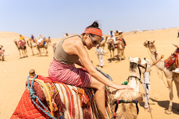 Tourist on top of a camel on a desert tour