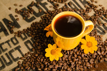 cup of coffee on a table with roasted coffee beans with a natural background
