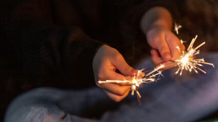 Celebrating in Christmas and New Year festival, Festive burning sparkler with sparks in hands, Enjoy playing with small sparkler hand fireworks.