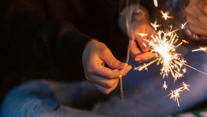 Celebrating in Christmas and New Year festival, Festive burning sparkler with sparks in hands,...
