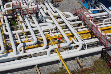 Top view male worker inspection at steel long pipes and pipe elbow valve in station oil factory during refinery valve of visual check record pipeline oil