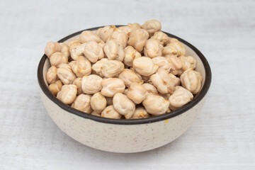 Chickpeas (garbanzo bean) in a ceramic bowl, isolated on white background, close up view