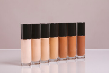 range of shades of liquid foundation in bottles isolated on background sale of beauty products...