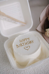 Fototapeta premium Bento cake decorated by golden inscription Happy Birthday. Cakes for one person