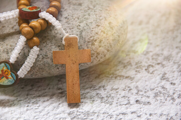 Holy Rosary on top of stone with bright light shining. Spiritual and Christianity concept