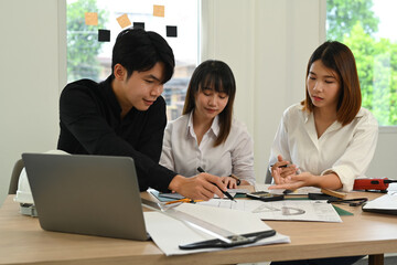 Professional team of architects brainstorming, working together on new project and building sketches in modern office