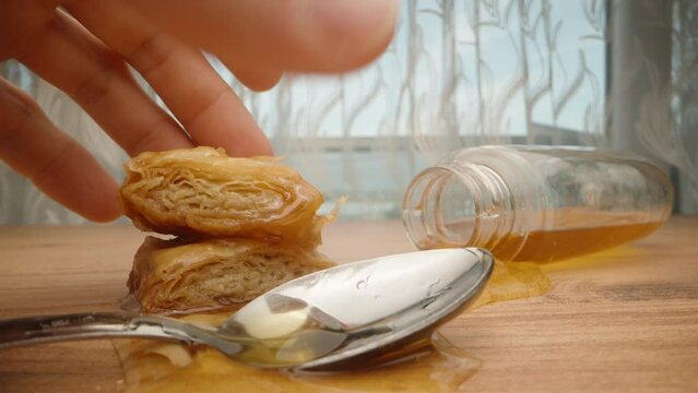 Turkish sweets and a jar of honey are on the table. I 'll take one . In motion, close-up.