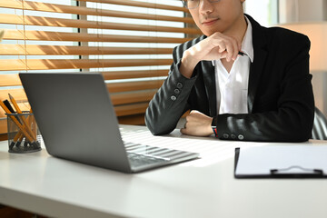 Focused businessman analyzing financial online data on laptop computer screen